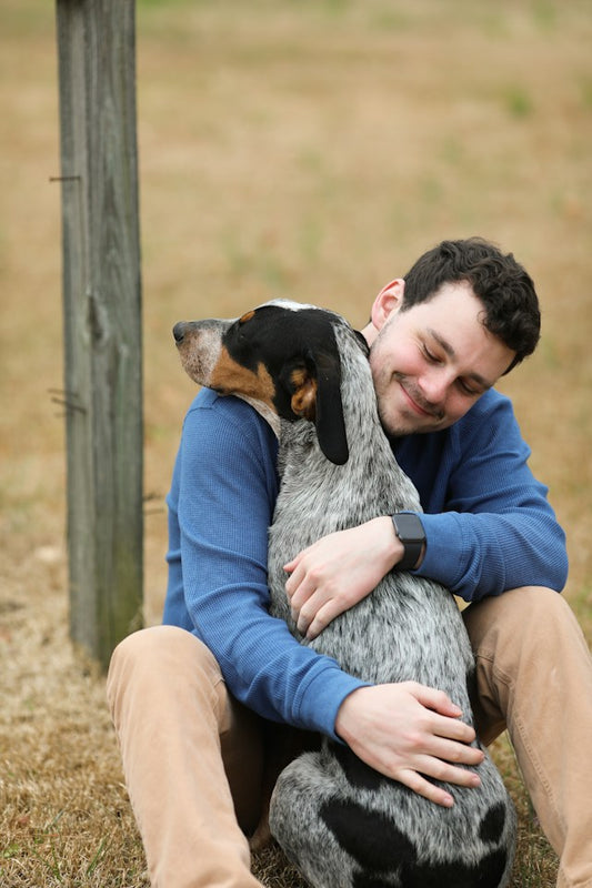 A man and his dog embrace while spending time together. If you are looking for ways to celebrate Valentine's Day 2024 with your dog or with a dog parent, or need gift ideas or inspiration, read our blog post! Photo by Cynthia Smith on Unsplash. 